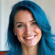 Portrait of Elara Thorne, a comic book artist with vibrant blue hair and a warm smile.